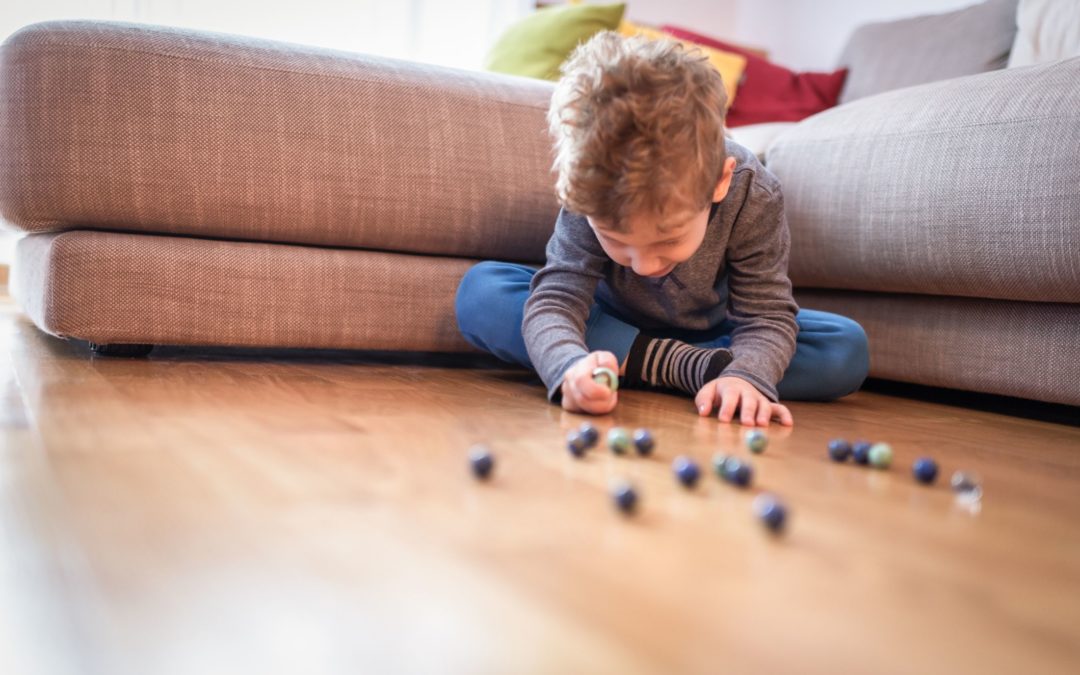 Brincadeiras dentro de casa. Criança jogando Ludo, um clássico dos